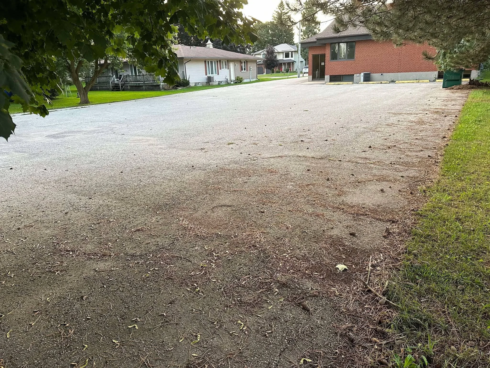 Before photo of a worn, faded asphalt parking lot pavement ahead of professional asphalt driveway sealing
