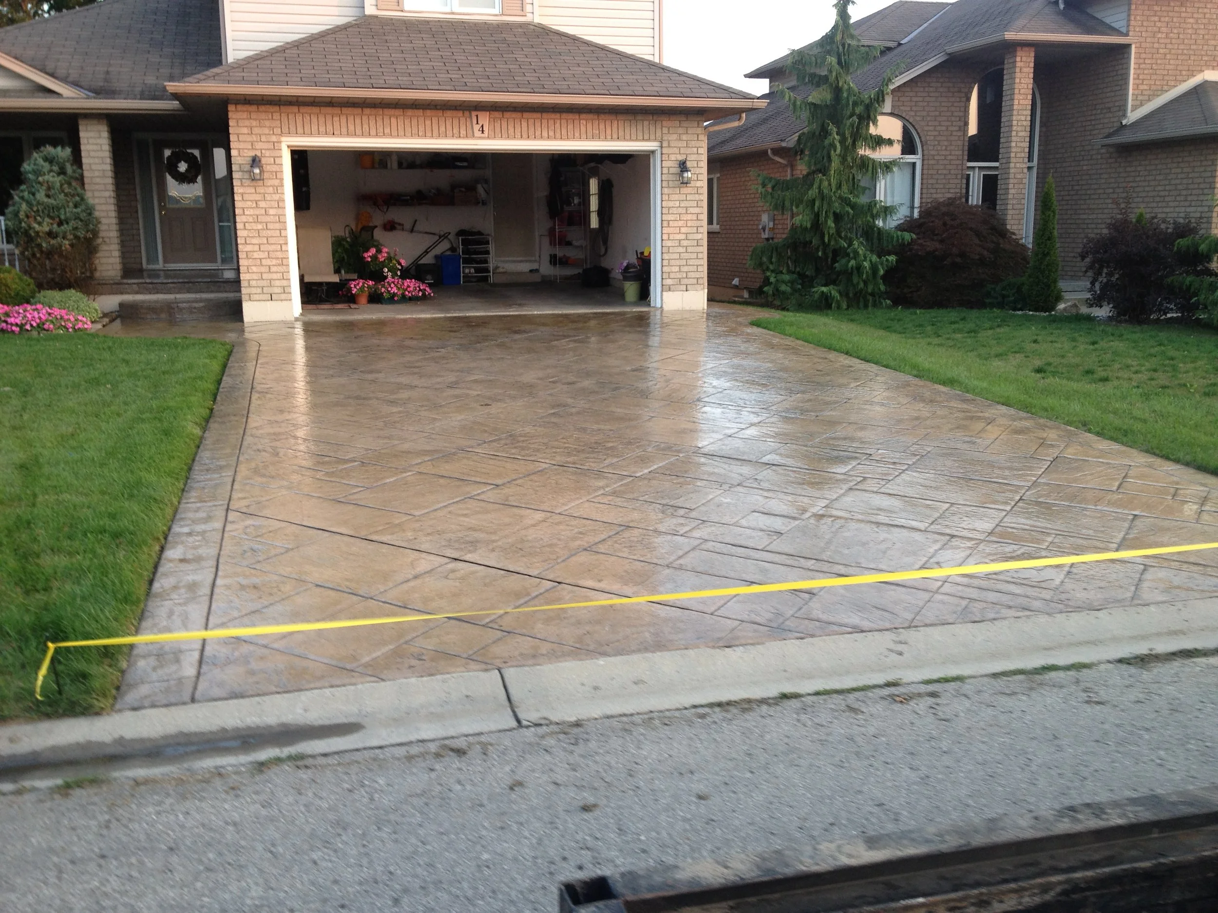 Wet concrete driveway glistening after professional concrete sealing, Kitchener