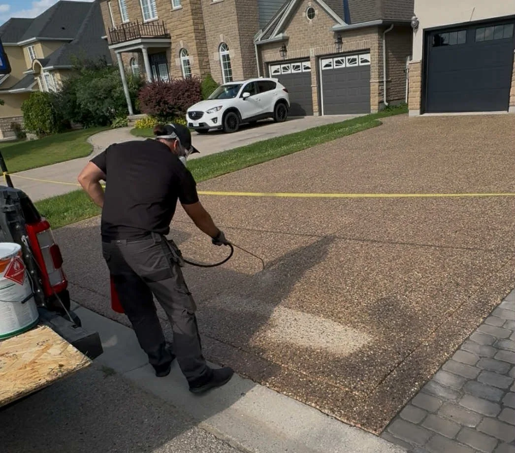Spray-applying concrete sealing on a driveway, Waterloo