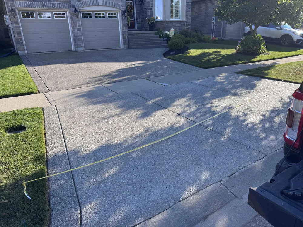 An aggregate concrete driveway power washed and flagged off