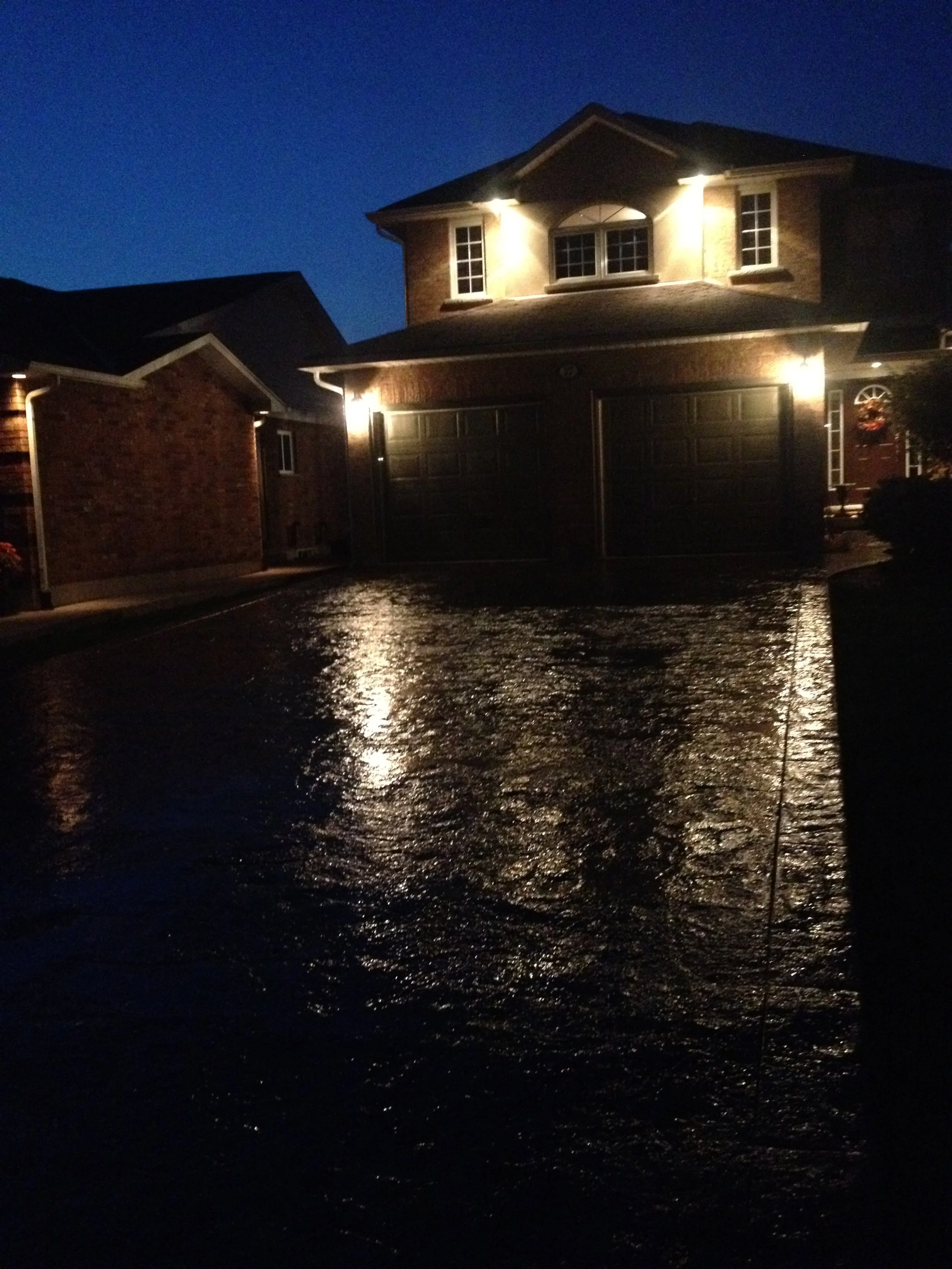 Concrete driveway glistening after concrete sealing at night, Kitchener